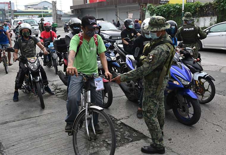 Policías armados realizan el control en Manila al entrar de nuevo restricciones por la pandemia de Covid-19. Foto AFP