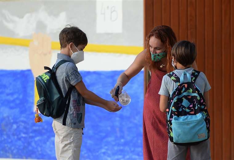 Una profesora desinfecta las manos al inicio de clases en una escuela de Sevilla. Foto AFP