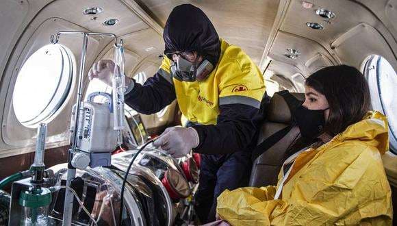 Un enfermo de covid llevado en el avión. Foto AFP