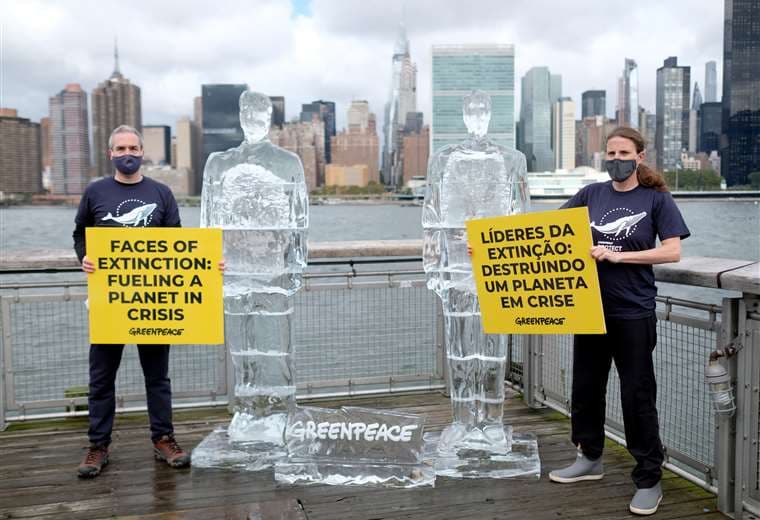 Gente de Greenpeace junto a las esculturas de hielo. Foto AFP