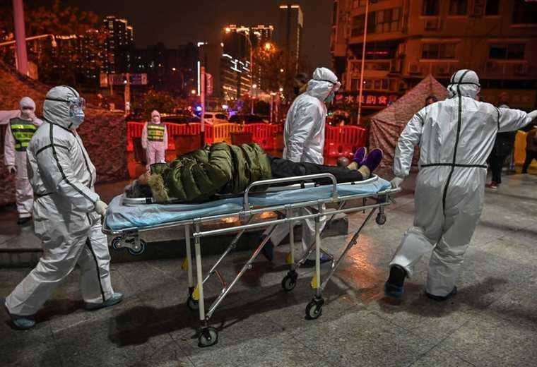 El 21 de enero de 2020 en Wuhán, personal médico auxiliando a un paciente de covid | AFP
