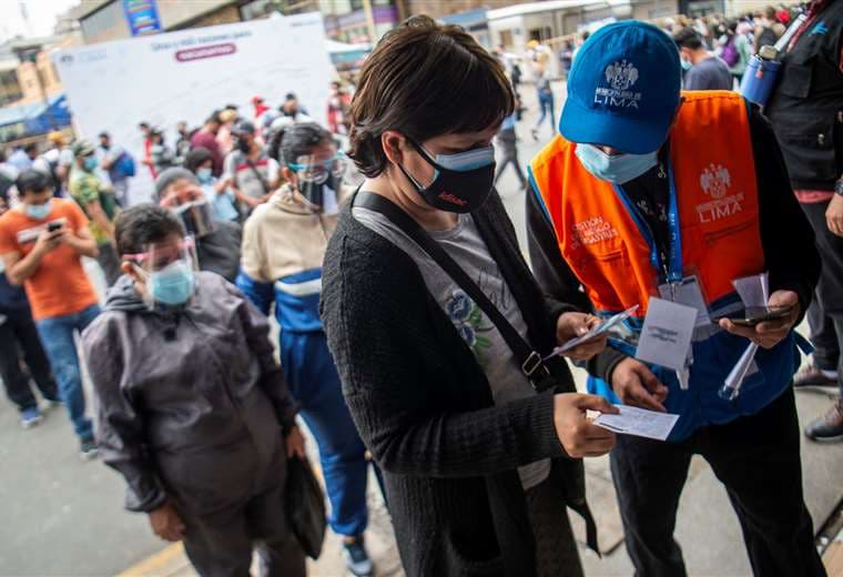 Personal de seguridad de un mal en Perú revisa los certificados de vacuna/Foto: AFP