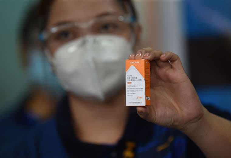 Un trabajador de la salud sostiene un frasco de la vacuna Sinovac