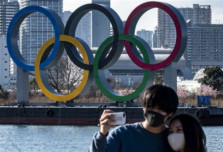 Una pareja posa para fotos frente a los anillos olímpicos. Foto: AFP. Foto: AFP