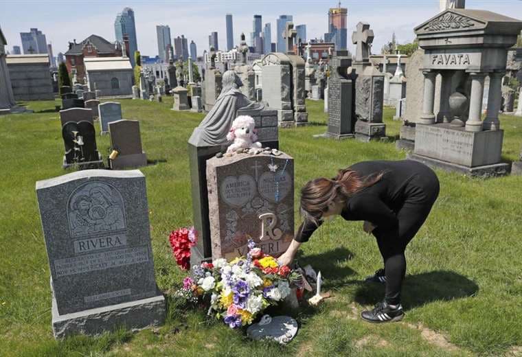 Una madre coloca flores en la tumba de su hija fallecida por sobredosis