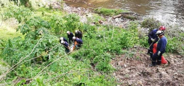 Los policías y peritos de la Fiscalía sacaron del rio el cadáver de la menor el viernes.