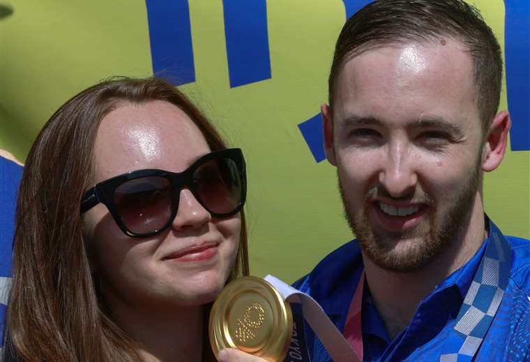 Dolgopyat, que aparece con su novia María Sakovic, muestra la medalla que ganó. AFP   