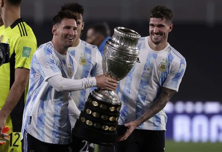 Messi  sostiene el trofeo de la Copa América junto a De Paul. Foto: AFP