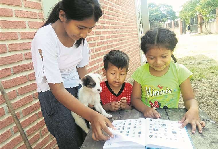 No tienen celular. Flavia Andrea enseña a leer a sus hermanos Claudia y Santi Rodrigo Foto: Deisy Ortiz