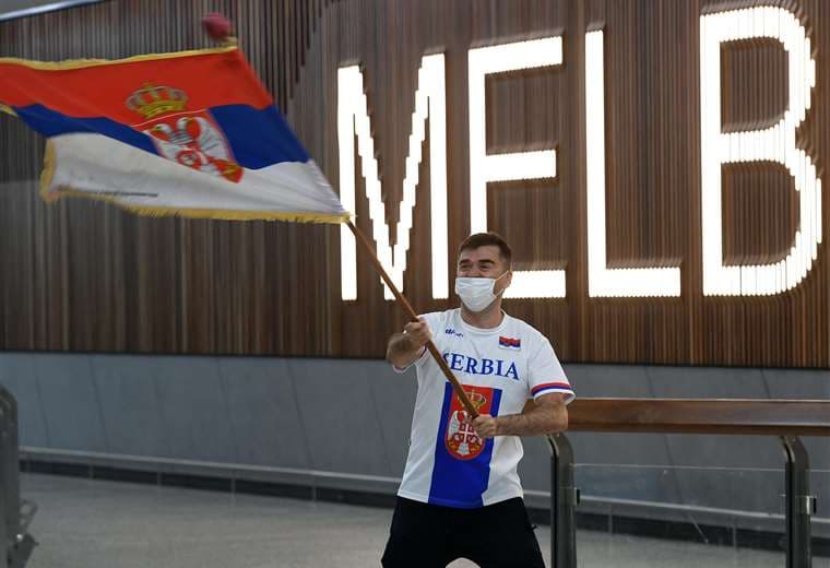 Un fan de Djokovic flamea la bandera de serbia en el aeropuerto de Melbourne. Foto: AFP