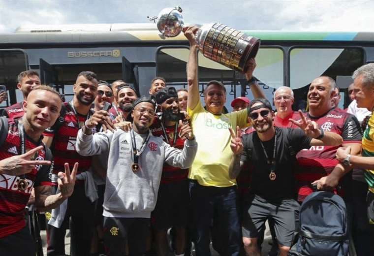 Jair Bolsonaro (con el trofeo) junto a los jugadores de Flamengo. Foto: AFP