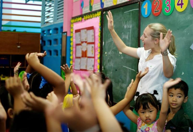 Voluntaria juega con niños en Tailandia