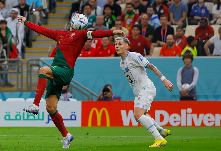 Cristiano trata de dominar el balón seguido de cerca por Varela, de Uruguay. Foto. AFP