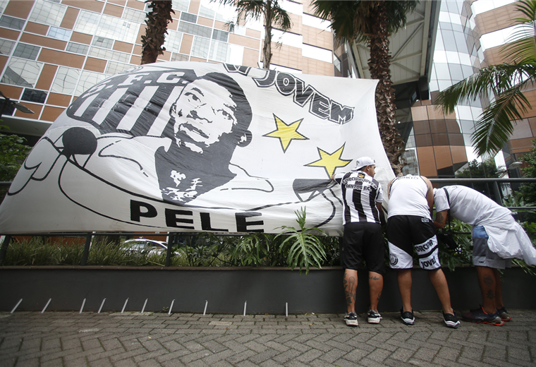 Hinchas brasileños colocan velas y una pancarta de aliento a Pelé. Foto. AFP