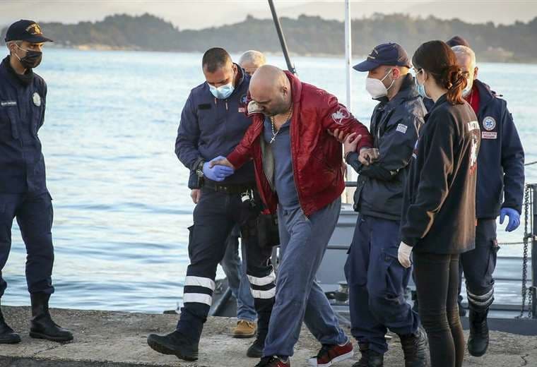 Los guardacostas ayuda a un pasajero el 18 de febrero de 2022 en el puerto de Corfú/ AFP