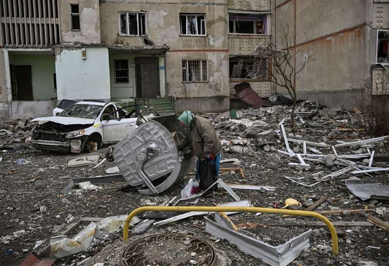 Una anciana camina entre los escombros cerca de un edificio dañado en Kharkiv/Foto: AFP