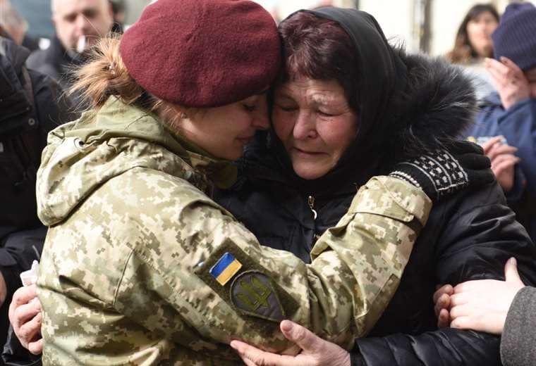 Una militar llora en los funerales de compañeros asesinados por tropas rusas. Foto AFP 