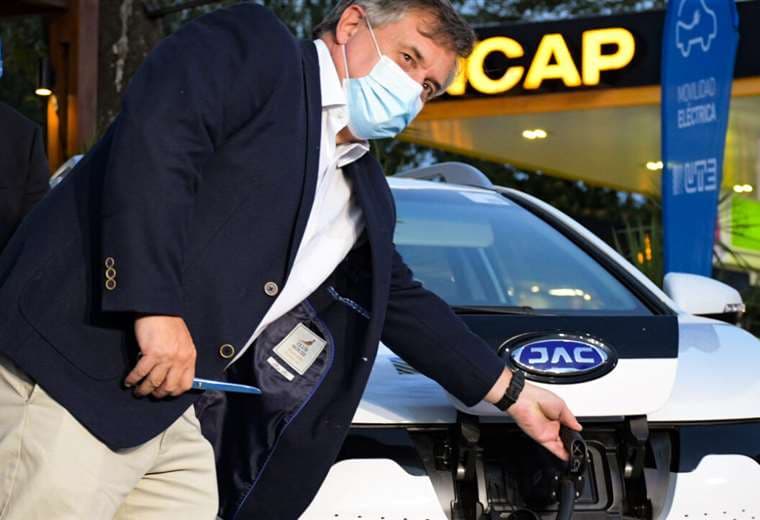 Omar Paginini, ministro de Industria, Energía y Minería, posa con un auto eléctrico.