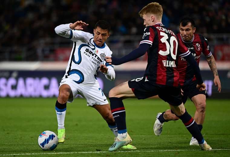 Alexis Sánchez, del Inter, intenta eludir a dos rivales del Bolonia. Foto: AFP