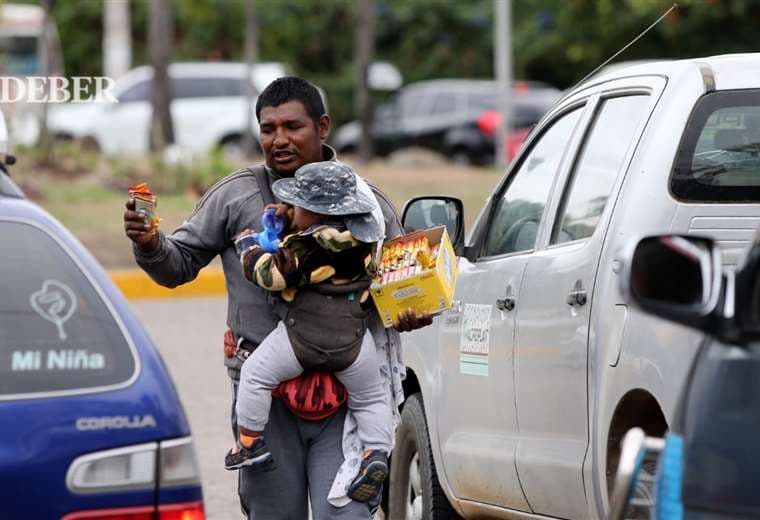 Ciro Barrientos carga a su hijo para poder vender en un semáforo / Foto: Ricardo Montero