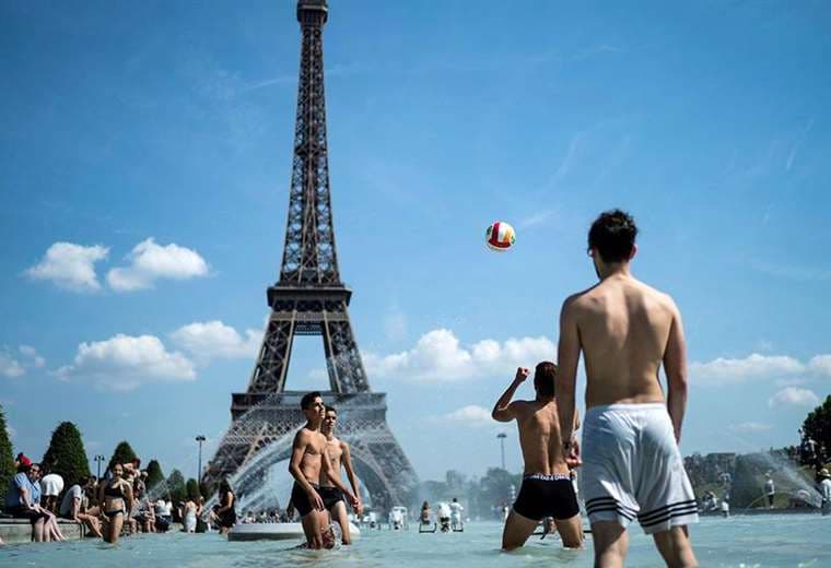 Jóvenes juegan en las fuentes de Paris para refrescarse. AFP