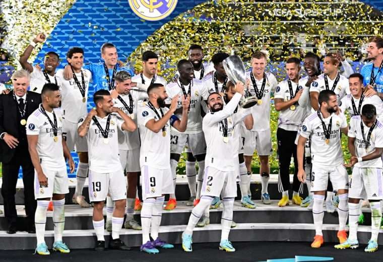 Los jugadores del Real Madrid con el trofeo que los acredita como campeones. Foto: AFP