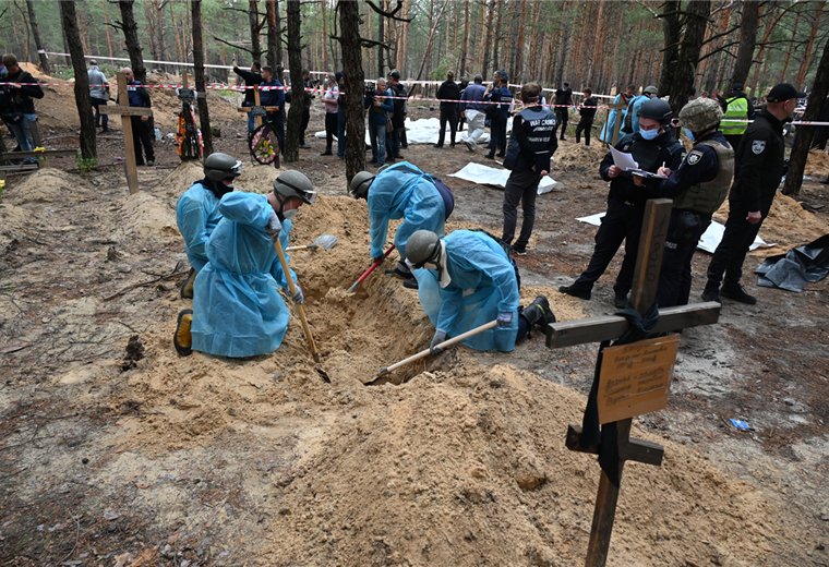 Forenses ucranianos cavan una tumba en un bosque en las afueras de Izium. Foto. AFP 