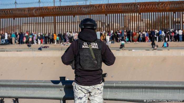 Un guardia nacional mexicano observa desde Ciudad Juárez a los migrantes 