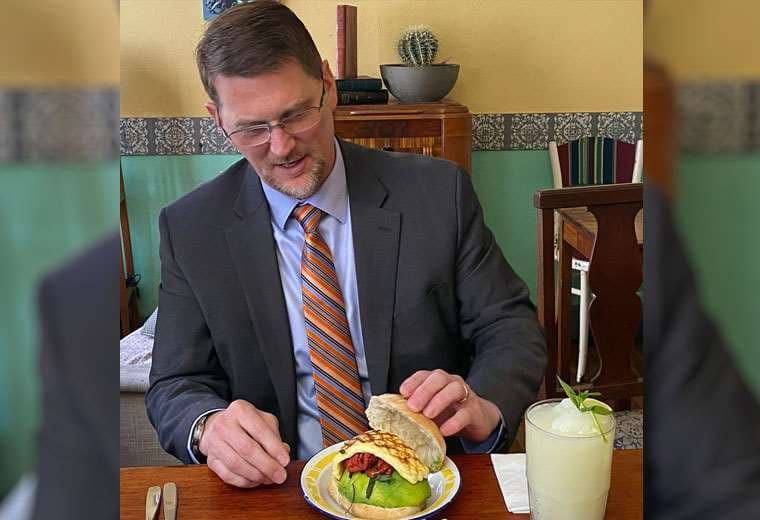 Mark Wells prueba un sándwich de palta. Foto: Embajada. 