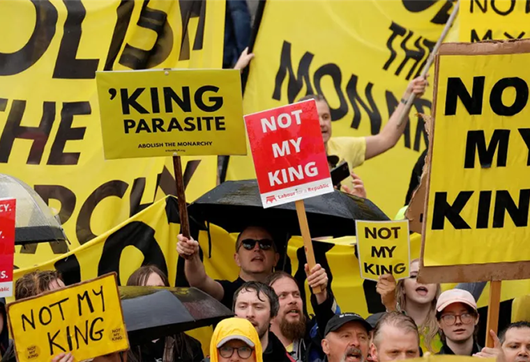 Los opositores a la coronación salieron con pancartas y chamarras amarillas. Fotos. AFP