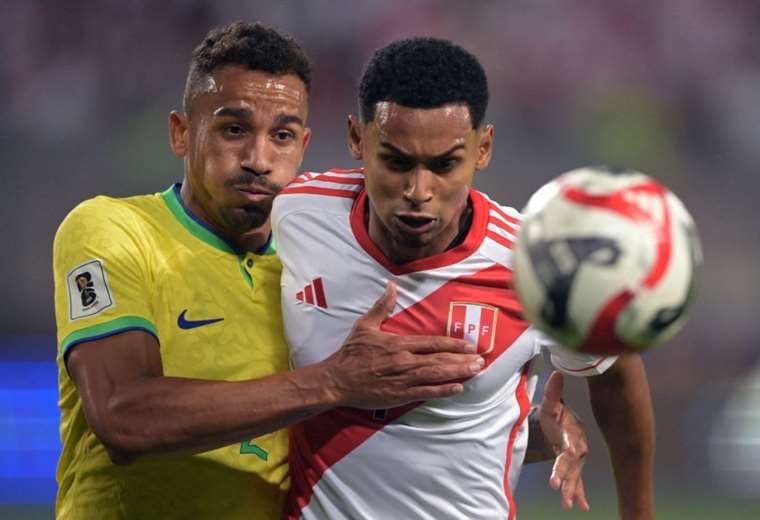 Danilo, de Brasil, y Marcos López luchan por hacerse del balón. Foto: AFP